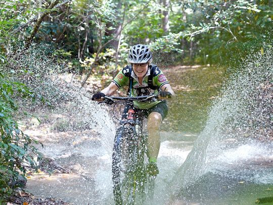mountain biker joyfully trashes creek habitat